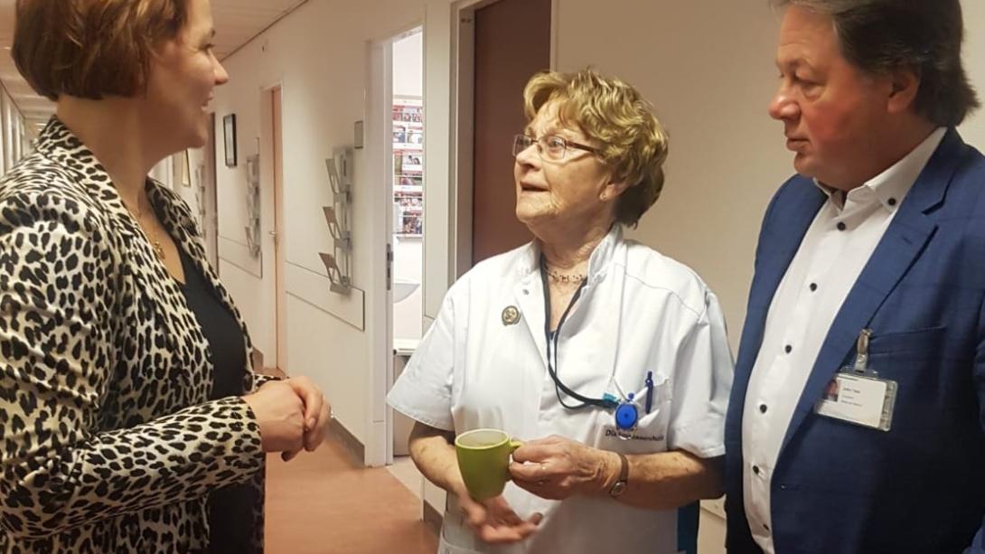 Judith Tielen en bestuurder John Taks in gesprek met zuster Ali, een 90-jarige diacones die al 72 jaar in het Utrechtse stadsziekenhuis werkt.