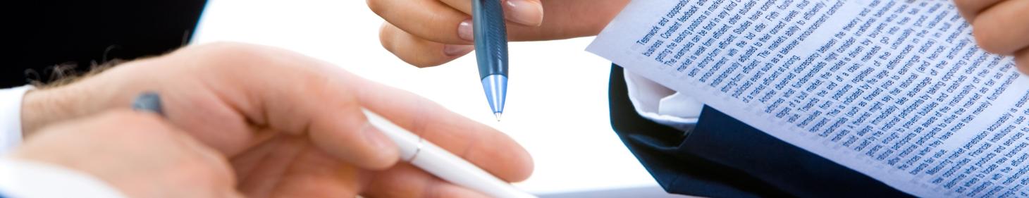 Mannen zitten aan tafel met papier en pen om contract te tekenen