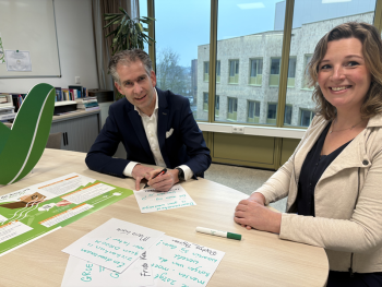 Hinke en Arend Jan aan een tafel met stift en papier